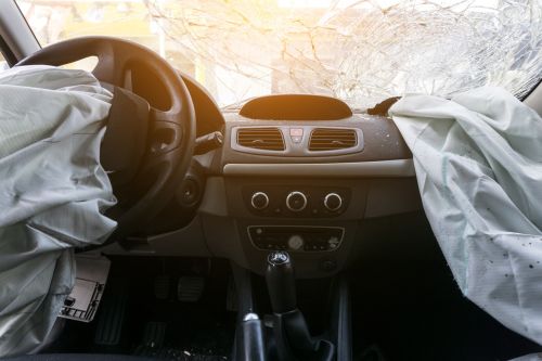 Damaged car dashboard with deployed airbags. Visual concept for legal blog discussing holding manufacturers accountable in wrongful death cases involving defective products.