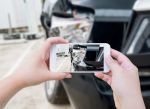 Female hold mobile smartphone photographing damage to car after a truck accident: Visual concept for: Preserving Evidence in Truck Accident Cases: What to Do After a Crash
